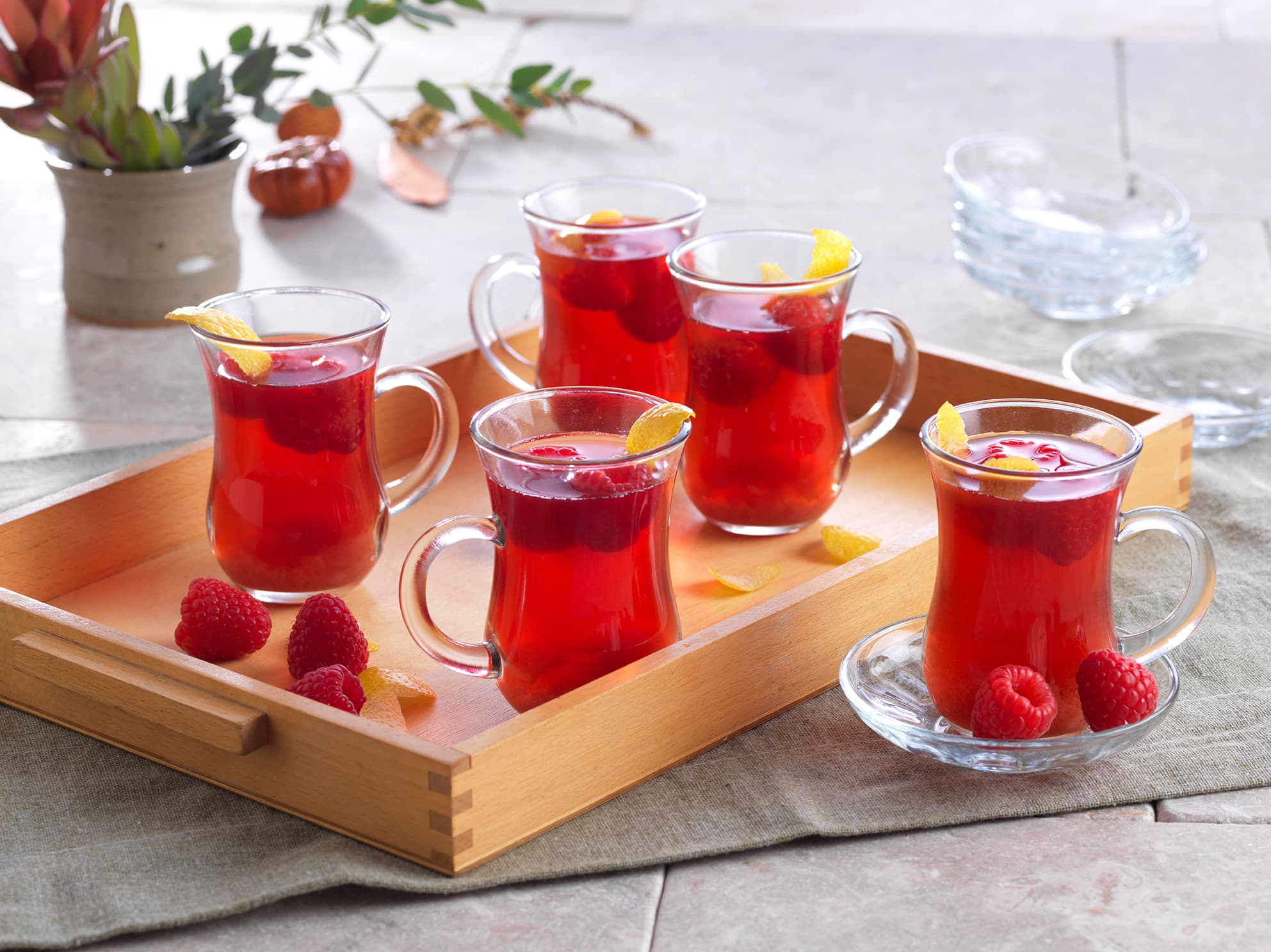 cups of hot cider with Driscoll's raspberries inside