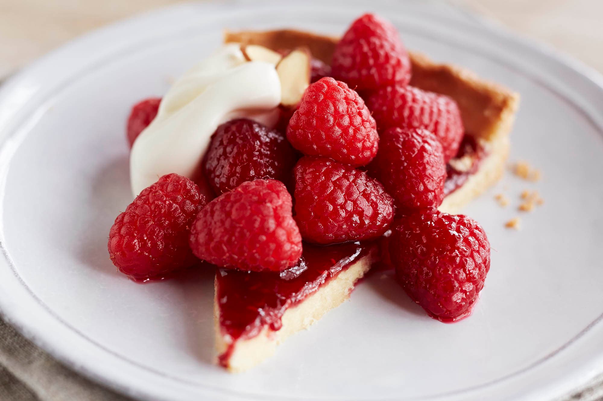 A slice of raspberry tart and raspberries
