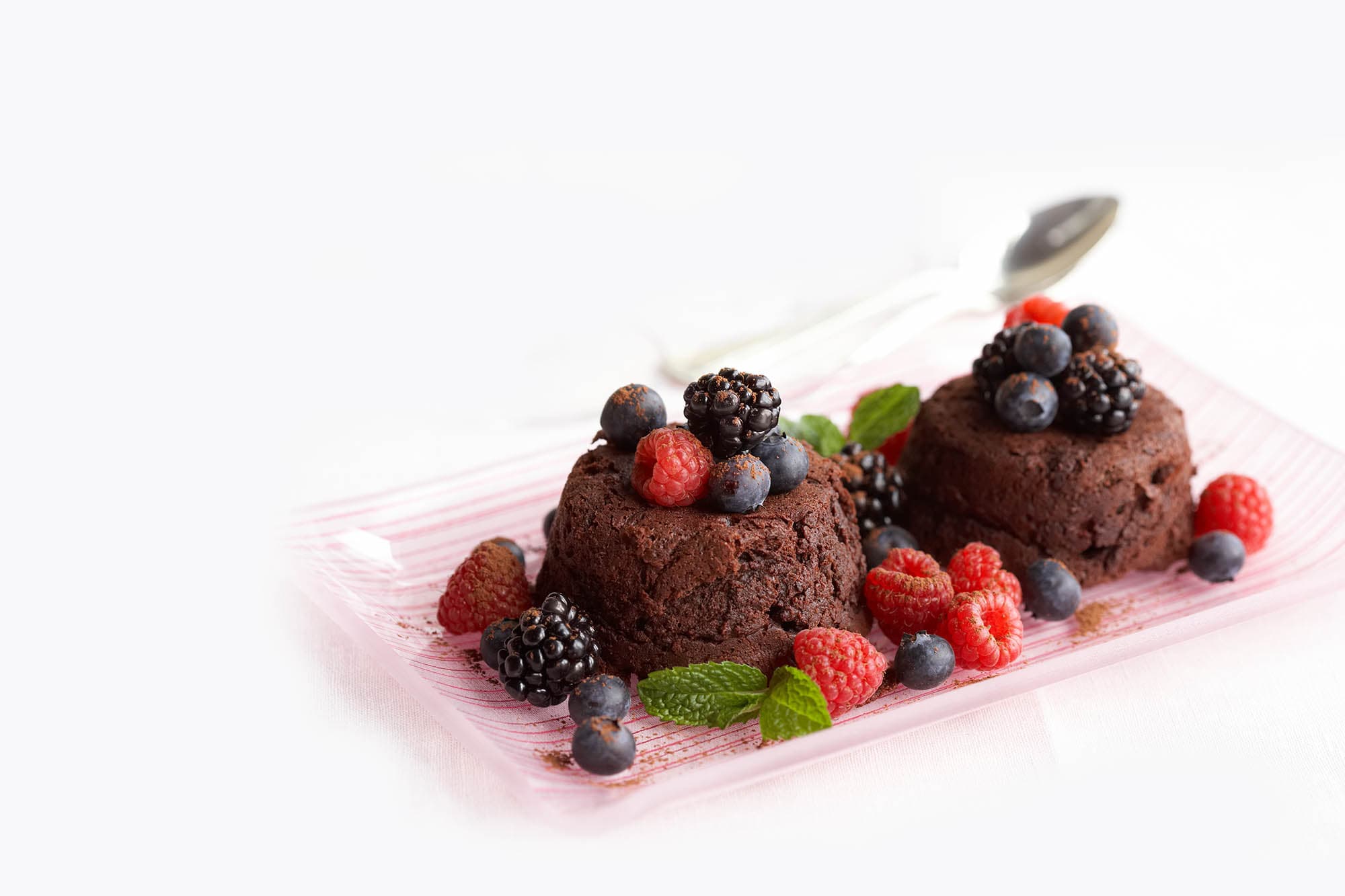 Mixed berry chocolate molten cakes topped with berries