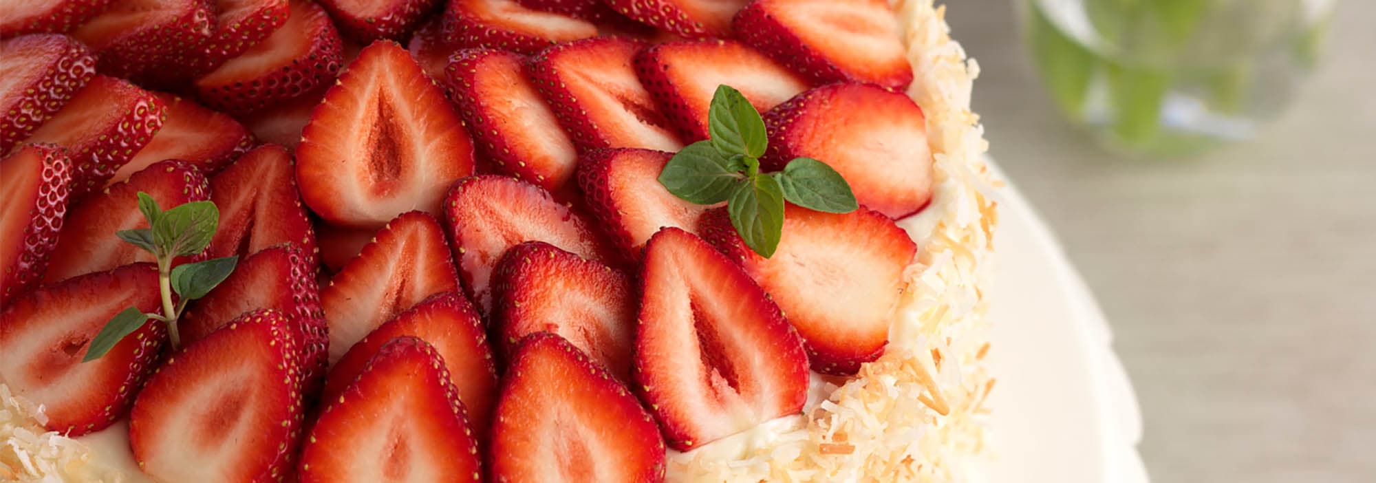 Strawberry coconut cake topped with sliced strawberries