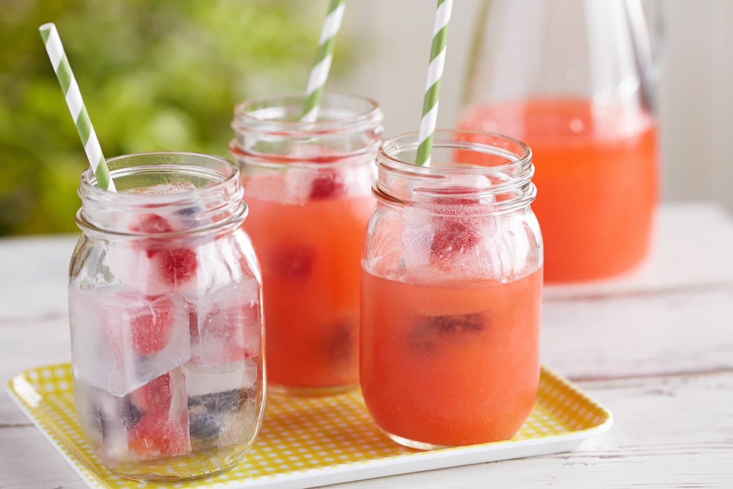 Cups with strawberry lemonade and berry ice cubes